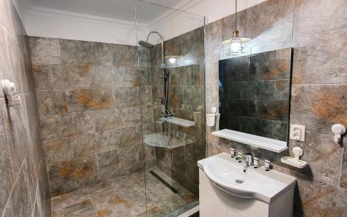 un bagno con lavandino e doccia di Mavie Apartment Boutique a Bucarest