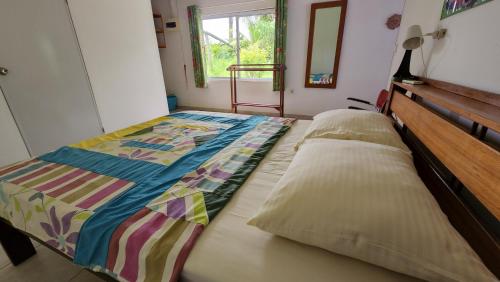 a bedroom with a bed with a quilt on it at Sutopia Holiday Resort in Meerzorg