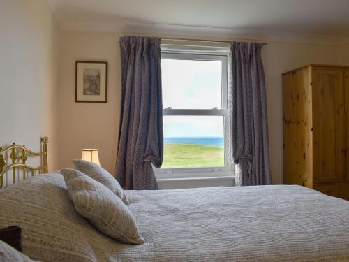 a bedroom with a bed and a large window at Seaview Apartment - 21 Spinnakers in Newquay