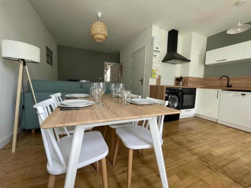 Il dispose d'une cuisine et d'une table à manger avec des chaises blanches. dans l'établissement Superbe T2 Neuf Centre Ville Wifi Terrasse Netflix, à Périgueux