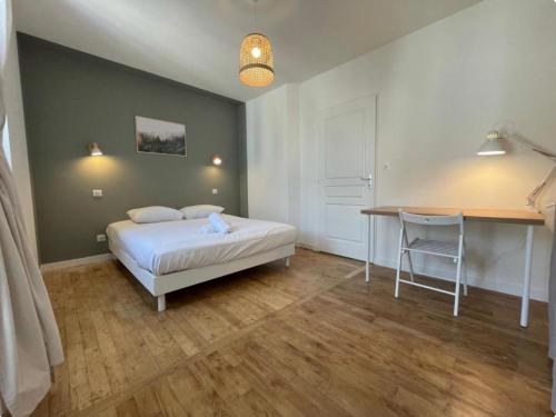 une chambre avec un lit, un bureau et une table dans l'établissement Superbe T2 Neuf Centre Ville Wifi Terrasse Netflix, à Périgueux