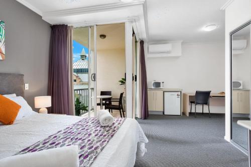 a hotel room with a bed and a balcony at City Quays Accommodation in Cairns