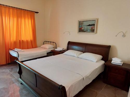 um quarto com 2 camas e uma cortina laranja em La Medusa Gardens em Iskele