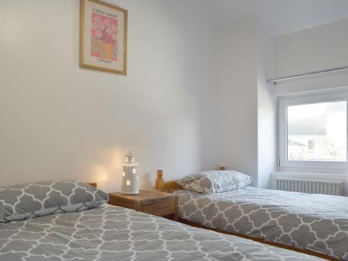 a bedroom with two beds and a window at Horton View Cottage in Ferryside