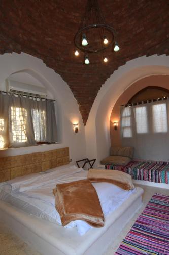 a bedroom with a large bed and two windows at Tzila Bahariya in Az Zaytūn