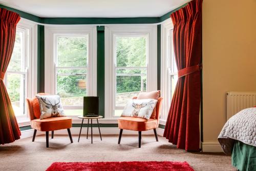 a bedroom with two chairs and two windows at Old Rose and Crown Hotel Birmingham in Rubery