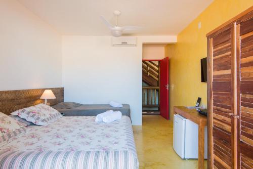 a bedroom with a bed and a dresser in it at Pousada Rosa dos Ventos in Praia do Forte