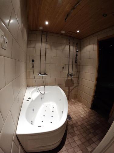 a large tub in a bathroom with a tiled floor at Levin Kolmio C2 in Kittilä