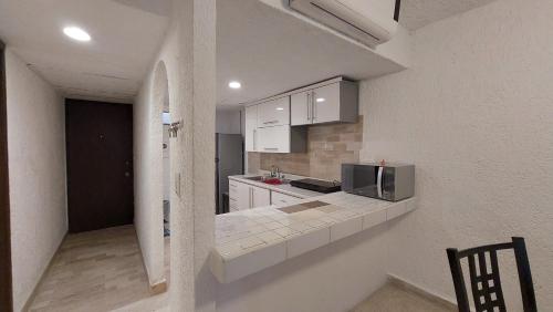 kuchnia z białymi szafkami i mikrofalówką w obiekcie Cancún Suites Apartments - Hotel Zone w mieście Cancún