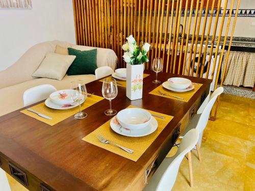 Corazón De Córdoba, la mejor ubicación في قرطبة: طاولة غرفة الطعام مع الأطباق وكؤوس النبيذ