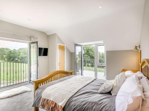 a bedroom with a bed and a large window at Upper Bryn Y Groes in New Bridge