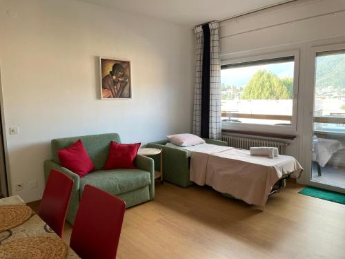 Habitación con cama, sofá y ventana en Karl&Deby Lugano stazione/centro en Lugano