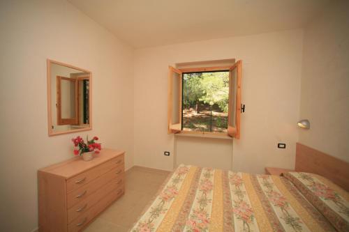 ein Schlafzimmer mit einem Bett, einem Fenster und einer Kommode in der Unterkunft Residence San Luca Vieste in Vieste