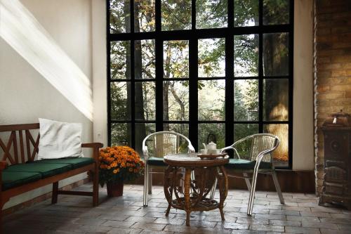 KismarosにあるNobuta Vendégházのテーブルと椅子、窓が備わる客室です。