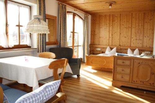 a room with a table and two beds in it at Haus Alpenlicht in Reit im Winkl