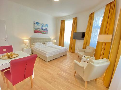 1 dormitorio con 1 cama, mesa y sillas en Steiner Residences Vienna Reumannplatz en Viena