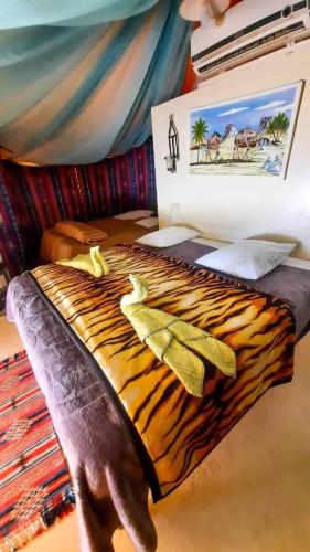 a bed with a fake tiger made up at Hotel Pansy in Ksar Ghilane