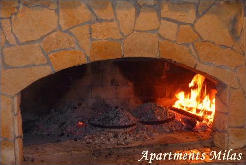 a brick oven with food cooking in it at Apartments Milas in Trogir