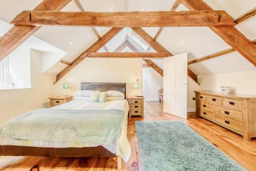 a bedroom with a large bed and wooden floors at Ysgubor Uchaf in Troedyraur