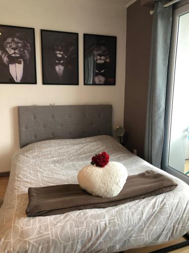 - un lit avec un oreiller blanc et une fleur rouge dans l'établissement Cosy-Adventure : Haguenau, à Haguenau