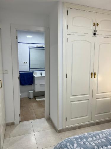 a bedroom with a white door and a bathroom at Fuengirola Paseo Marítimo 27 in Fuengirola