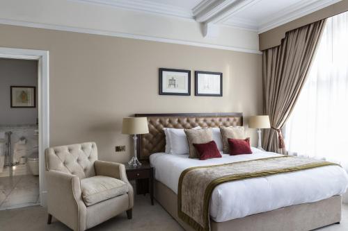 a bedroom with a large bed and a chair at St Paul's Hotel in London