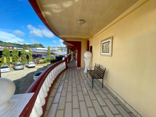 balkon z ławką i widokiem na ulicę w obiekcie Hotel Wilson Ciudad Neily w mieście Neily