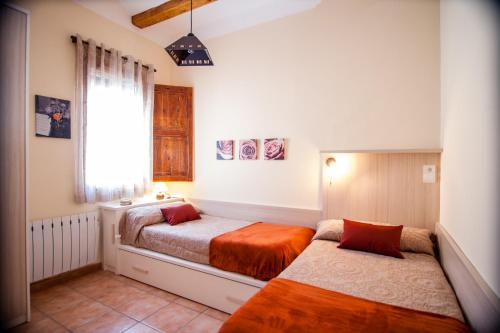 1 dormitorio con 2 camas y ventana en Colonia Apartamento Rural, en Bellmunt de Ciurana