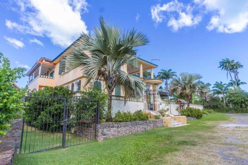 una casa con una palmera delante de ella en Habitation du Comté en Sainte-Rose