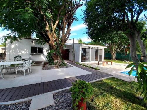 a patio with a table and chairs and a tree at Casa del Ancla Santa fe Social Golf Club in Cuernavaca