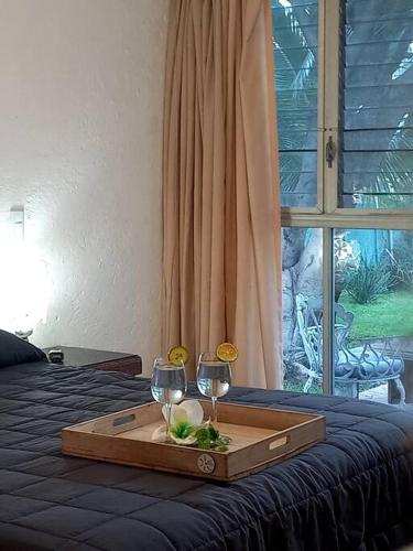 a tray with two wine glasses on a bed at Casa del Ancla Santa fe Social Golf Club in Cuernavaca