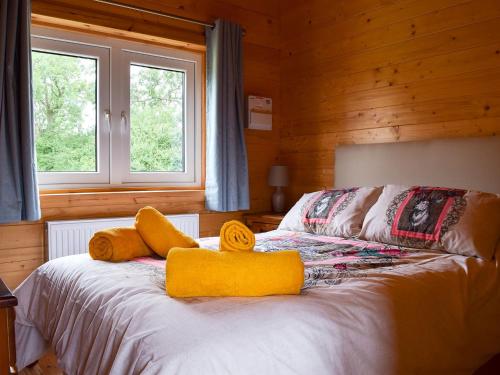 Raynards Retreat - Uk33401 في Hungerton: غرفة نوم عليها سرير وفوط صفراء