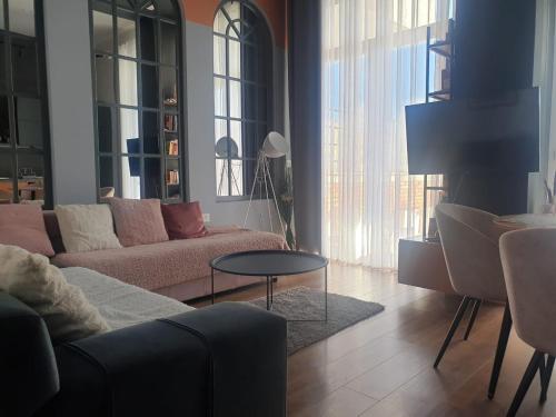 a living room with a couch and a table at Stylish two bedroom house with private pool in Tirana