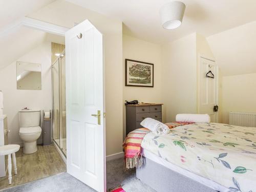 Dormitorio pequeño con cama y aseo en New Cottage en Farr