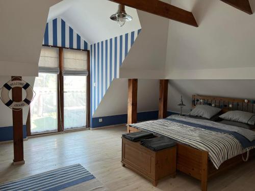 a bedroom with a bed with blue and white stripes at Bosio nad morze in Sztutowo