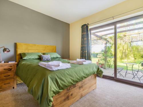 a bedroom with a bed and a large window at The Poplars in Catwick