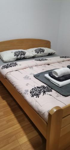 two beds with white sheets and black and white blankets at Apartman MAŠA in Jagodina