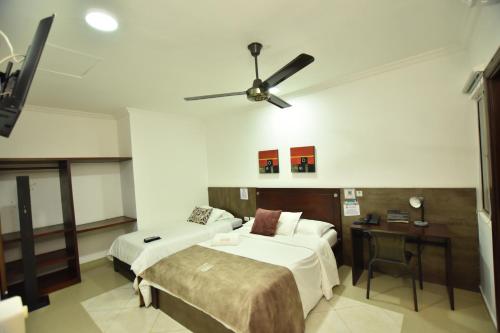 a hotel room with two beds and a ceiling fan at Hotel La Casa N. 3 in Montería