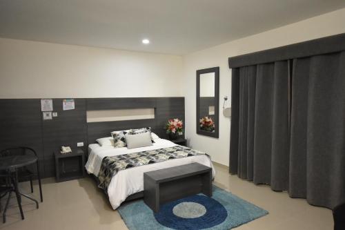 a bedroom with a large bed and a blue rug at Hotel La Casa N. 3 in Montería