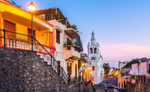 una calle de la ciudad con un edificio y una torre del reloj en JM GUESTHOUSE en Santo Domingo