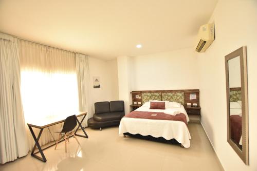a bedroom with a bed and a chair and a desk at Hotel La Casa N. 3 in Montería