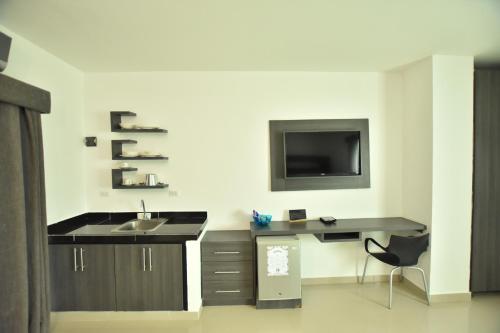 a bathroom with a sink and a tv on a wall at Hotel La Casa N. 3 in Montería