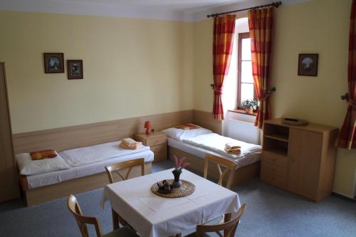 a room with two beds and a table and chairs at Apartmany A.Ša Kašperské Hory in Kašperské Hory