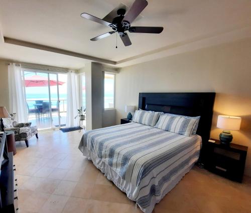 a bedroom with a bed and a ceiling fan at Stunning oceanfront condo on usable Sandy Beach in Rosarito