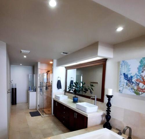 a bathroom with two sinks and a large mirror at Stunning oceanfront condo on usable Sandy Beach in Rosarito