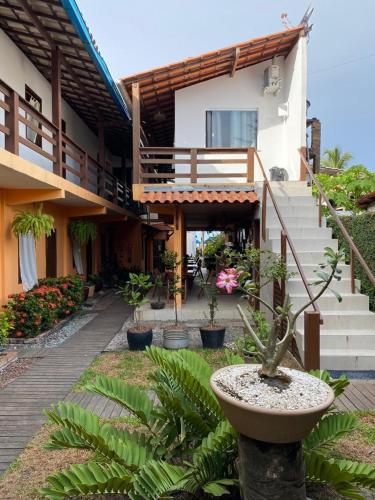 a building with a courtyard with potted plants in front of it at Tapirandú Pousada in Morro de São Paulo
