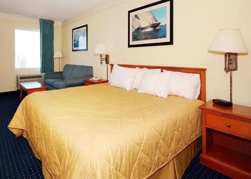 um quarto de hotel com uma cama grande e um sofá em Hatteras Island Inn em Buxton