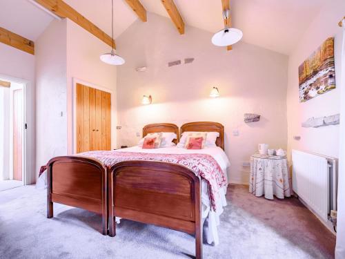 um quarto com uma cama grande e uma estrutura em madeira em Pickle Cottage em Carnforth