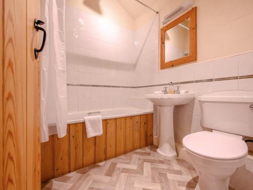 a bathroom with a toilet and a sink and a bath tub at Pickle Cottage in Carnforth