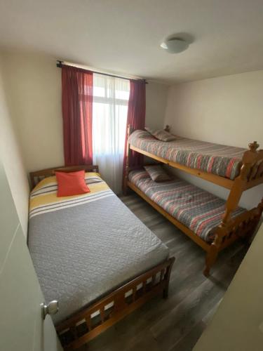 1 Schlafzimmer mit 2 Etagenbetten und einem Fenster in der Unterkunft Departamento en playa in La Serena
